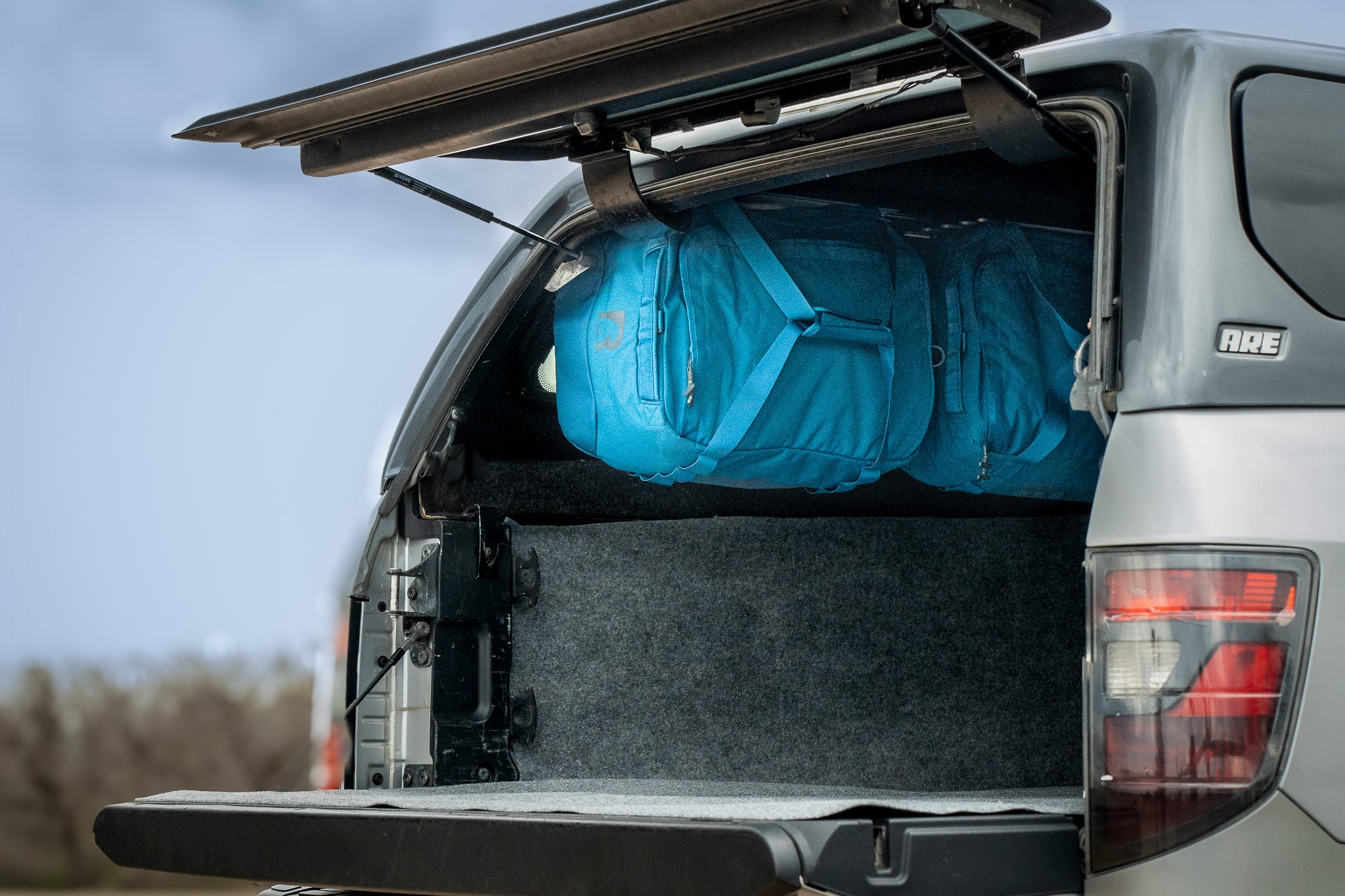 Truck topper duffel hanging system for efficient truck bed camping storage