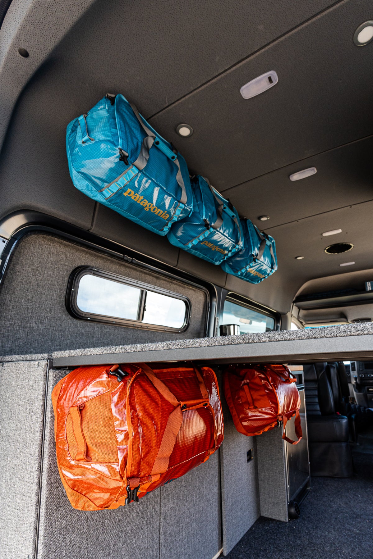 LoftLockers turn duffels into cabinets overhead and under the bed in a Sprinter van